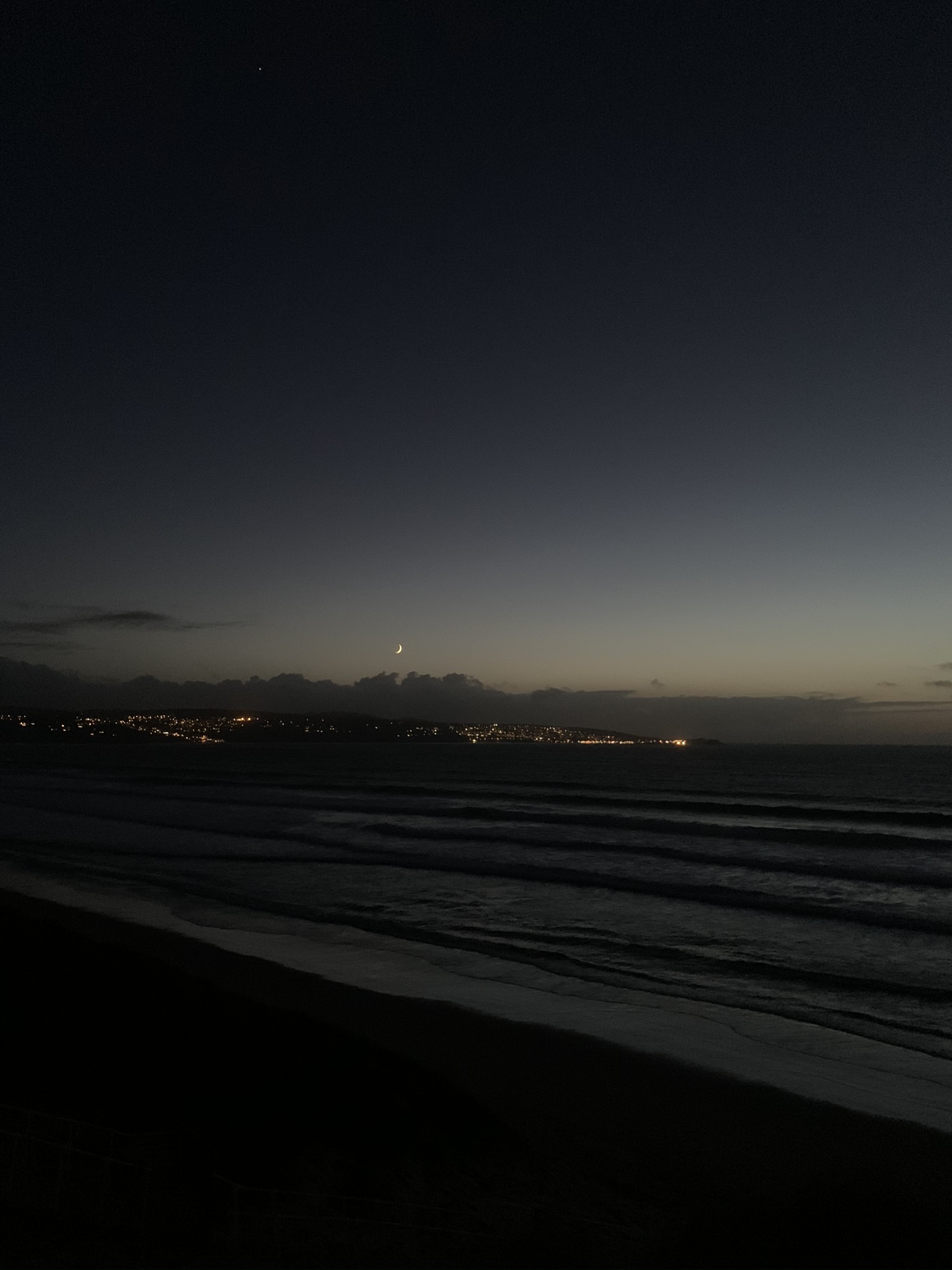 Night fall at St Ives Bay beach with the moon in the sky
